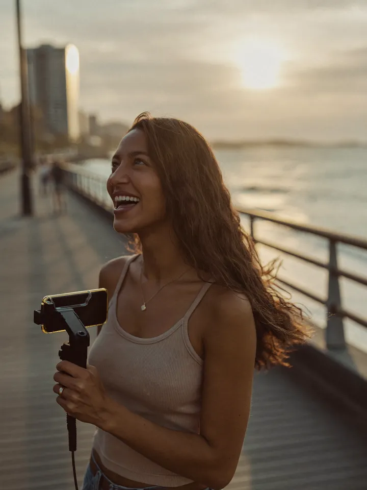Creator with her phone on the boardwalk at sunset