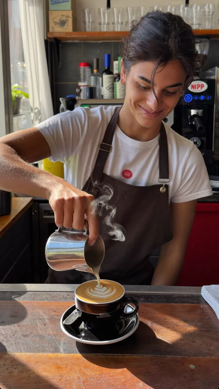 Barista pouring latte art in front of the camera